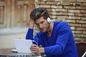 Young man with tablet pc touch in an cafe outdoor sitting