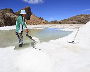 Young man, worker shovels salt
