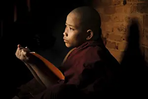 Young novice monk learning inside monastery