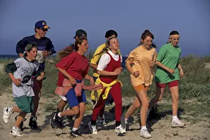 Young people jogging on the beach, group