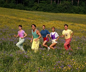 Young people jogging through flower meadow