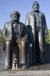 Young pug in front of Marx and Engels monument in Berlin