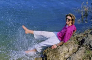 Young woman on the beach, feet in the water