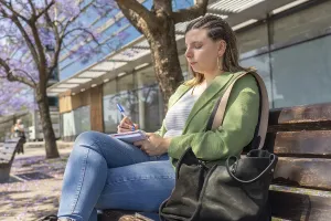A young woman with braided hair sitting on a bench
