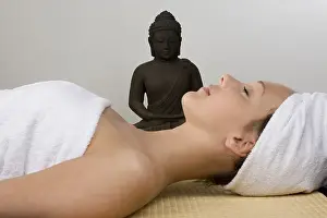 Young woman next to a Buddha statue