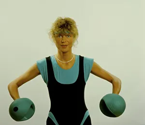Young woman doing gymnastics with dumbbells