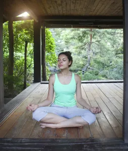 Young woman doing yoga asana in the evening outdoors