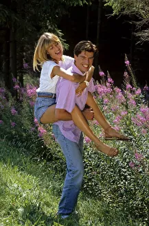 Young woman embraces young man walking in the forest
