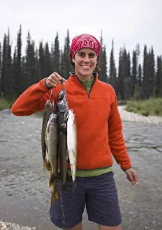 Young woman fishing, presenting her catch