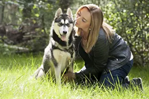 Young woman and her husky in the forest