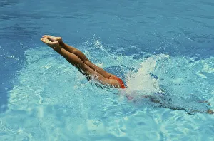 Young woman jumps into the swimming pool