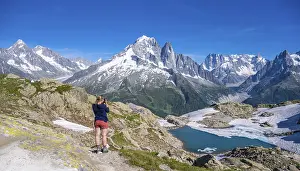 Young woman photographs mountain panorama