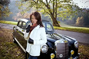 Young woman in front of post-war classic car