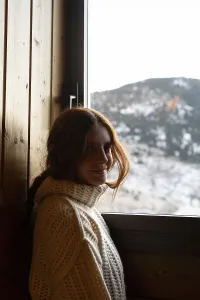 A young woman with red hair wearing a cozy