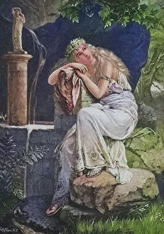 Young woman sitting daydreaming by the fountain in the garden