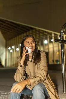 Young woman sitting outdoors at night