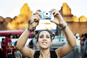 Framed Print : Young woman taking pictures at a street market