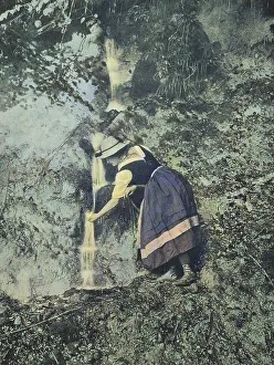 Young Woman Wandering Drinking Water by a Stream