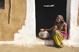 Faces Of The World Prints: Young woman with water jug at the entrance to her house