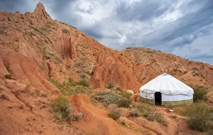 Yurt between eroded mountain landscape