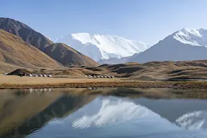 Yurts, mountains reflected in a small mountain lake