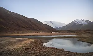 Yurts, mountains reflected in a small mountain lake
