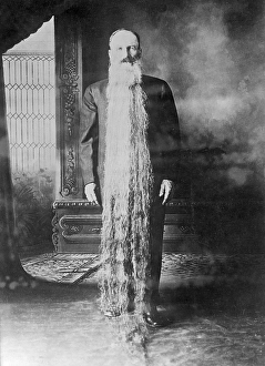 Zacharias T. Wilcox from Carson City Nevada. Famous for having a beard that is more than two meters long. He is pictured standing with the beard hanging from his head down to the floor