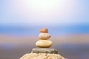 Zen balanced small pile of stacked stones on the beach in summer
