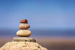 Zen balanced small pile of stacked stones on the beach in summer