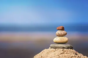 Zen balanced small pile of stacked stones on the beach in summer