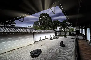 Zen garden with textured sand patterns and rocks surrounded by traditional Japanese architecture