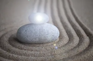 Zen stones with shining light on sand with customizable space for text or message